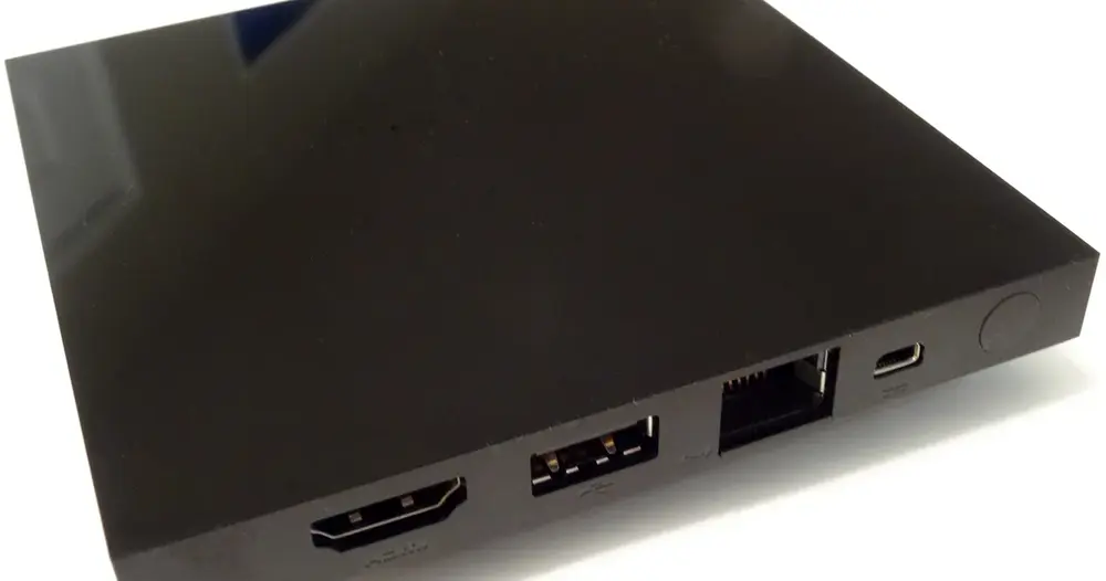 Aparelho TV box preto com entradas HDMI e USB visto de perto